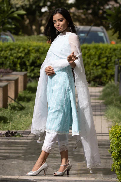 A woman standing and wearing Kesar Blue Colored Sleeveless Suit Set.