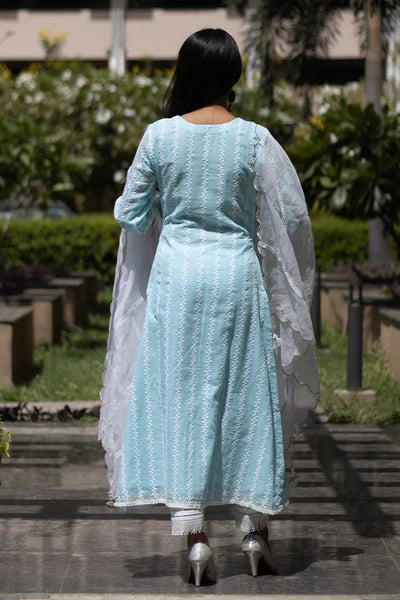 A woman standing and wearing Kesar Blue Colored Suit Set.