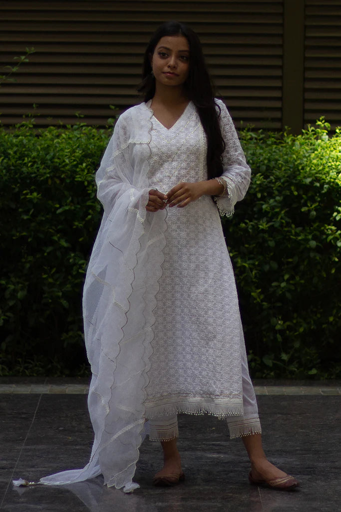 A woman standing and wearing Kesar Ivory Colored Suit Set.