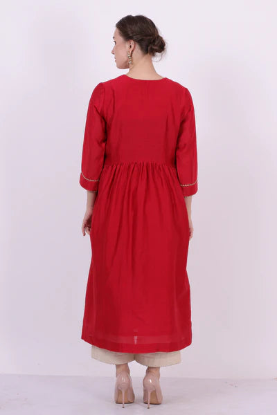 A woman standing and wearing Saroj Red Colored Kurta Shirt.