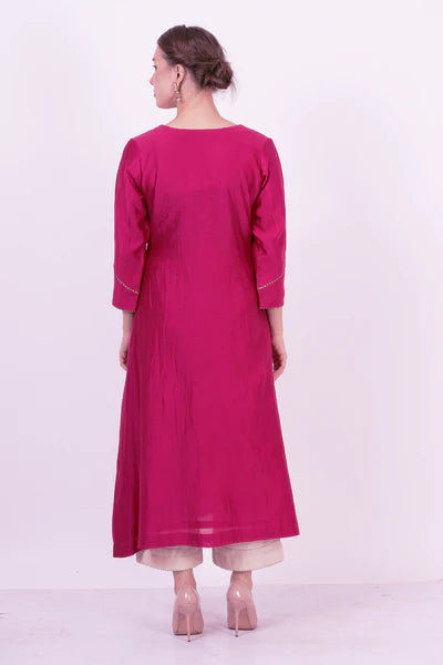 A woman standing and wearing Saroj Wine Colored Ethnic Dress.