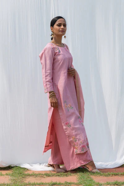 A woman standing and wearing Titli Onion Pink Colored Suit Set.