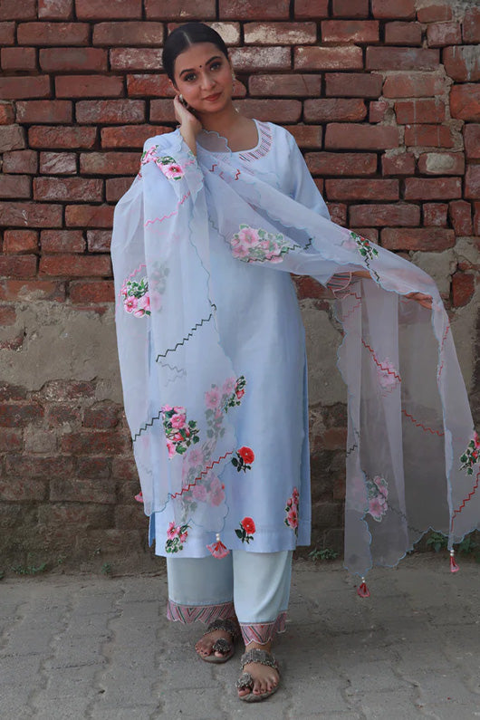 A woman standing and wearing Vaidehi Sky Blue Colored Suit Set.