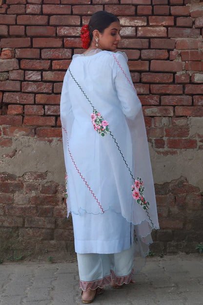 A woman standing and wearing Vaidehi Sky Blue Colored Suit Set.