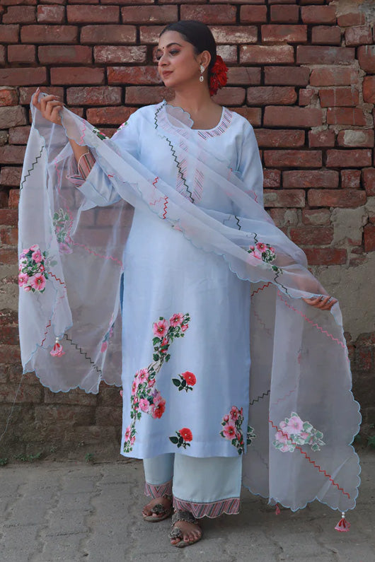  A woman standing and wearing Vaidehi Sky Blue Colored Suit Set.