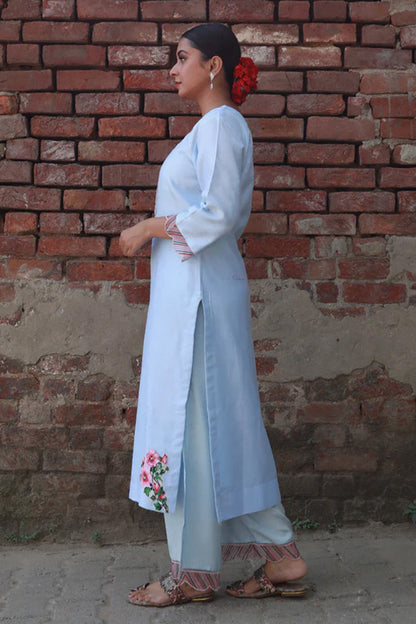  A woman standing and wearing Vaidehi Sky Blue Colored Suit Set.