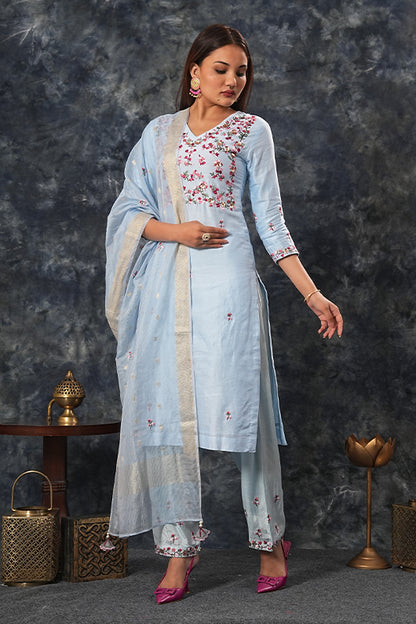 A woman standing and wearing Saumya Sky Blue Colored Suit Set.