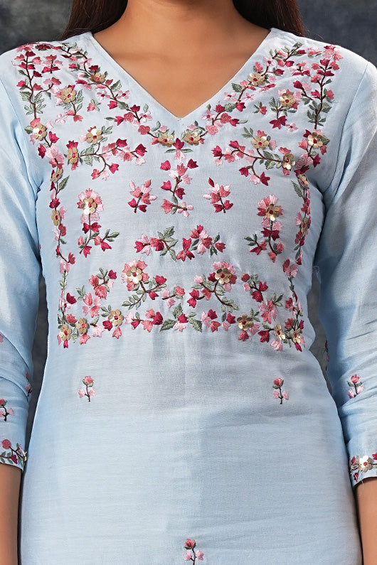 A woman standing and wearing Saumya Sky Blue Colored Suit Set.