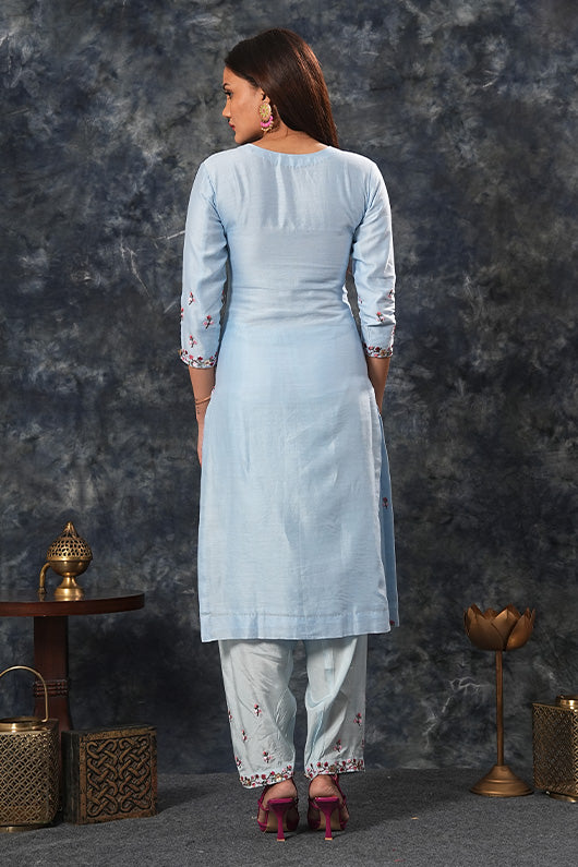 A woman standing and wearing Saumya Sky Blue Colored Suit Set.