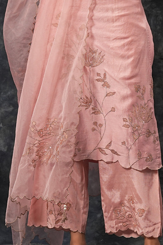 A woman wearing pink colored suit with pants.