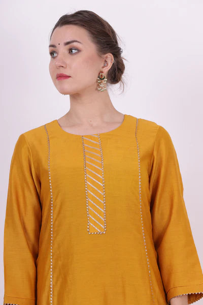 A woman standing and wearing Kaavya Yellow Colored Shirt.