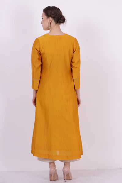 A woman standing and wearing Kaavya Yellow Colored Shirt.