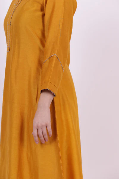 A woman standing and wearing Padma Yellow Colored Kurta Shirt.