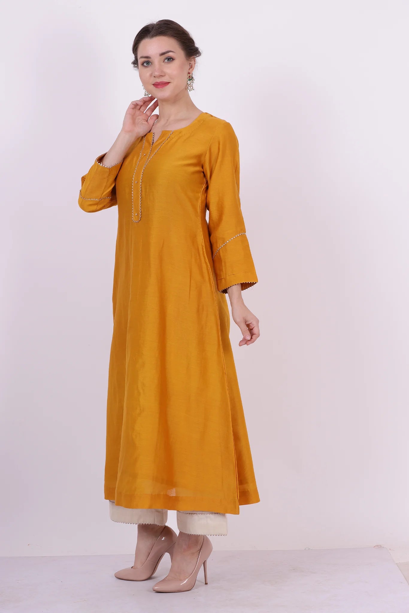 A woman standing and wearing Padma Yellow Colored Kurta Shirt.