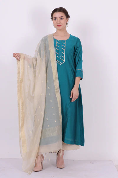 A woman standing and wearing Kumud Turquoise Colored Shirt.