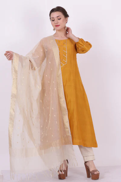 A woman standing and wearing Kumud Yellow Colored Shirt.