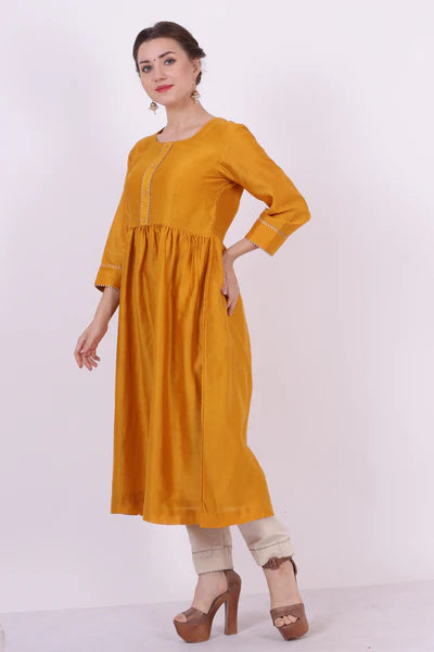 A woman standing and wearing Sarol Yellow Colored Kurta Shirt.