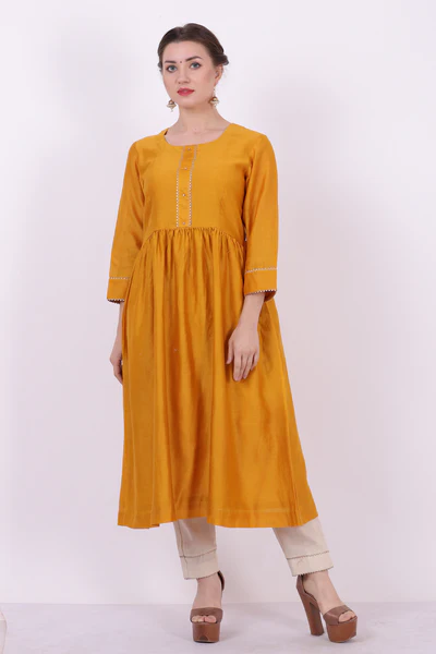 A woman standing and wearing Sarol Yellow Colored Kurta Shirt.