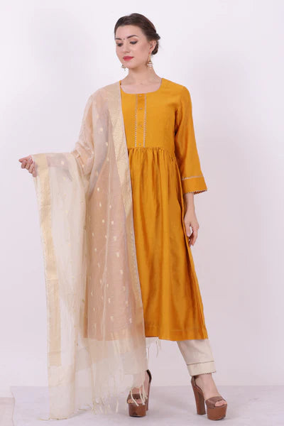 A woman standing and wearing Sarol Yellow Colored Kurta Shirt.