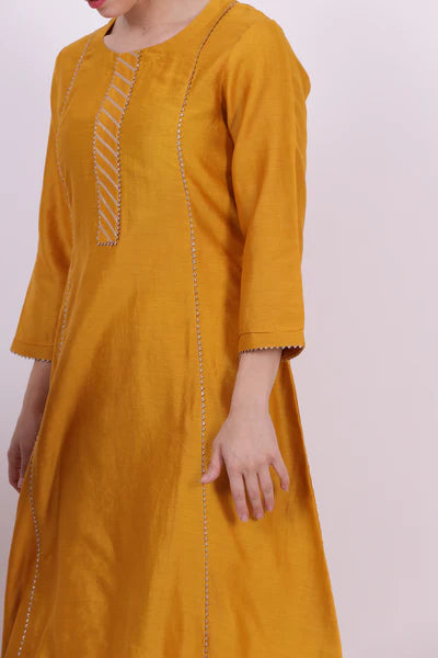 A woman standing and wearing Sarol Yellow Colored Kurta Shirt.